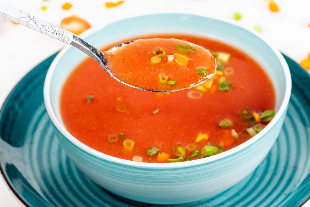 Tomato soup with herbs in a spoon