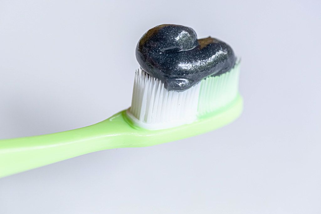 Toothbrush with black charcoal toothpaste