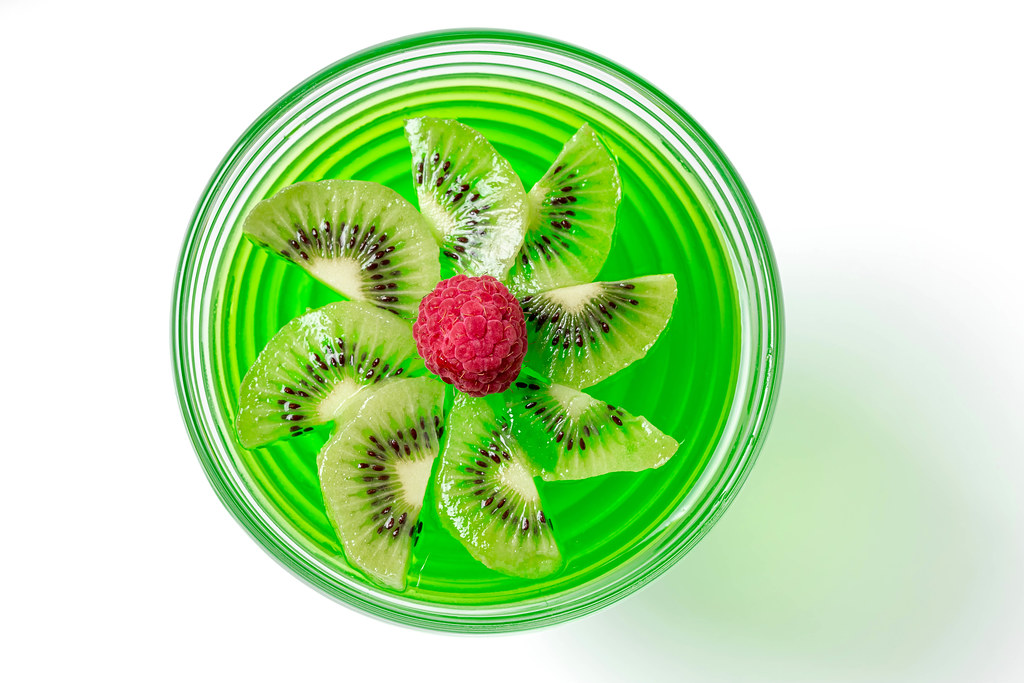 Top view, green jelly with kiwi slices and raspberries