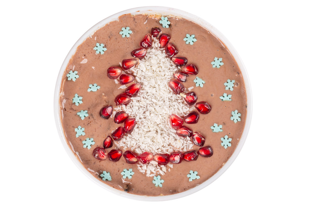 Top view, oatmeal with chocolate yogurt, pomegranate and coconut in the form of a christmas tree