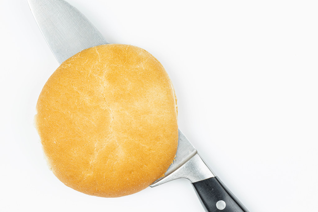 Top view of Knife in the Bread above white background with copy space