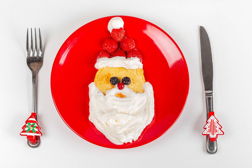 Top view of santa claus head made from pancakes, berries and whipped cream