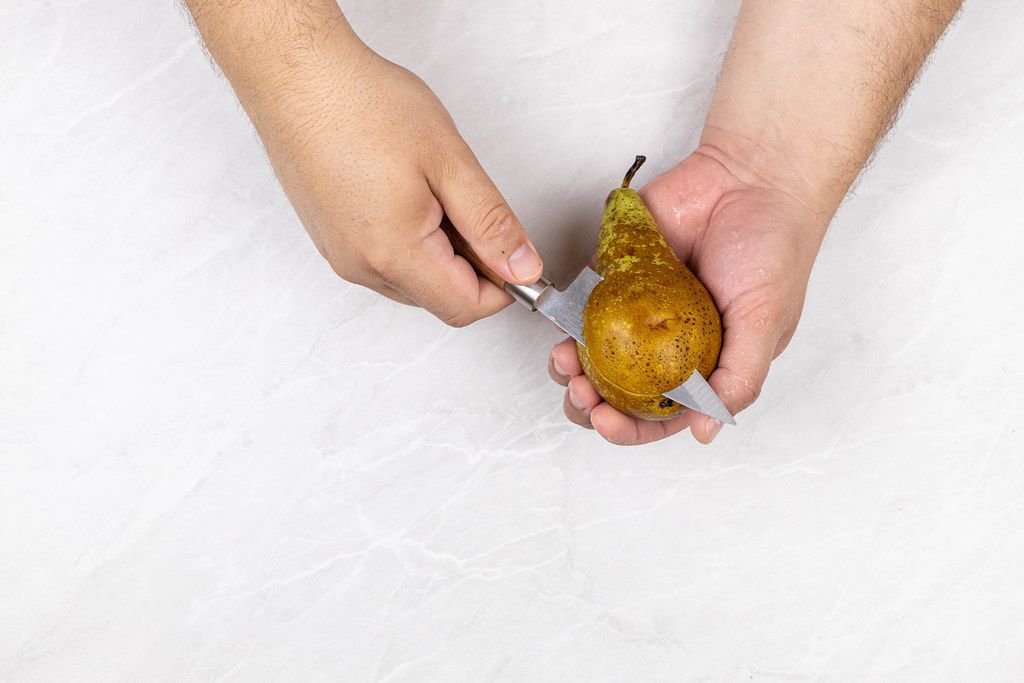 Top view of slicing Pear in the hands