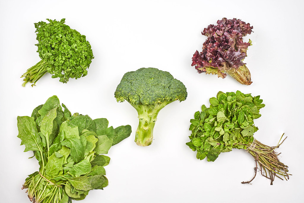 Top view of various leafy greens on white