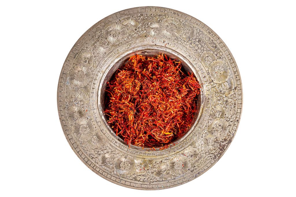 Top view, saffron spice in metal bowl on white background