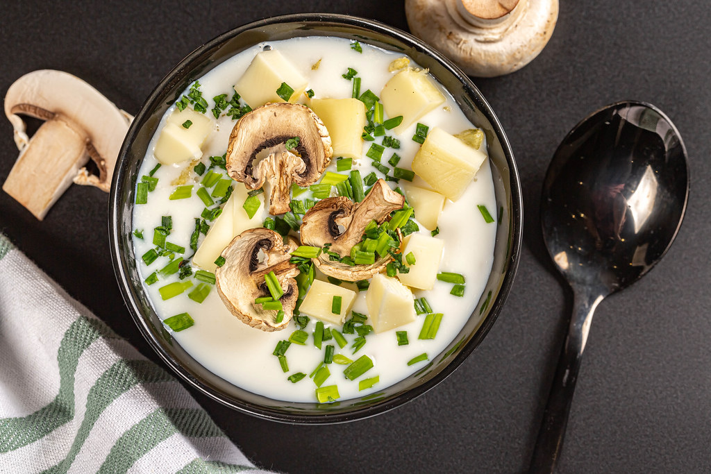 Top view, soup with mushrooms, cheese and herbs