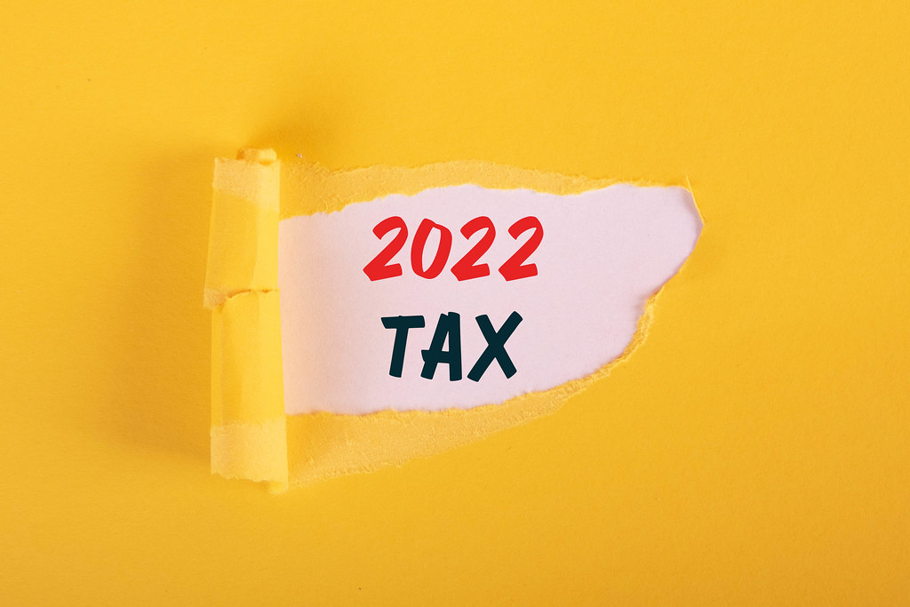 Torn paper revealing 2022 Tax text