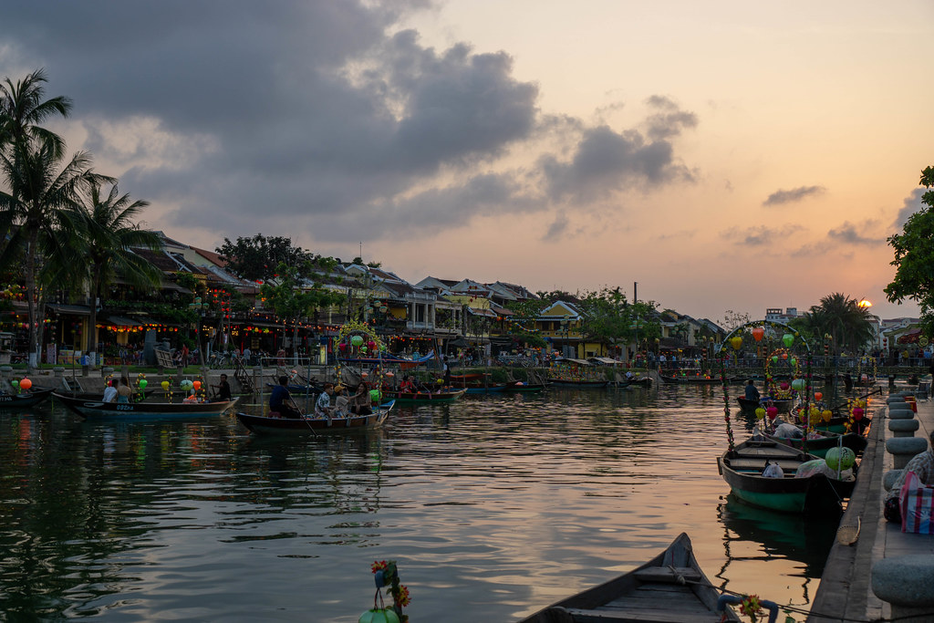 Tourist Boats with Lanterns on Thu Bon River along the many Shops and Restaurants at Sunset in the Ancient Town of Hoi An, Vietnam
