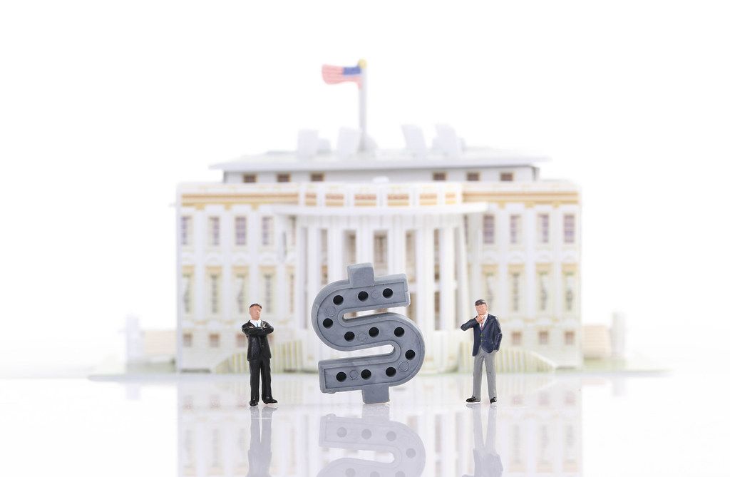 Two businessman standing in front of White House with Dollar sign