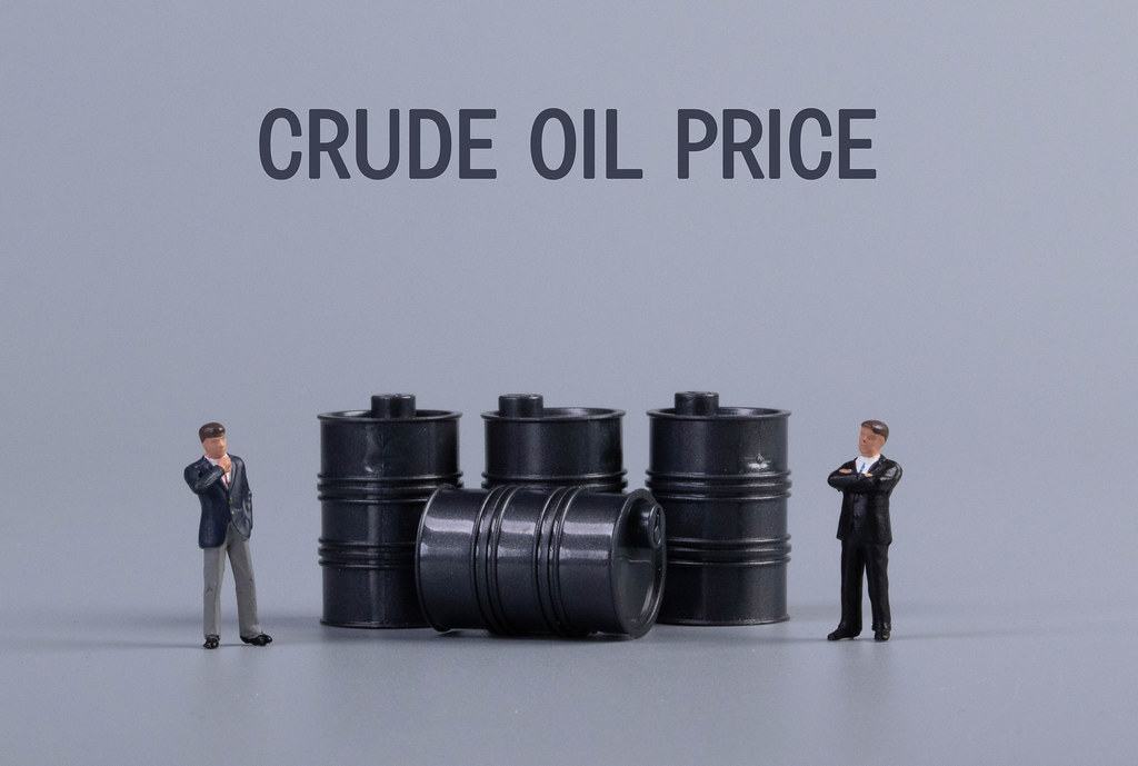 Two businessman with oil barrels and Crude Oil Price text