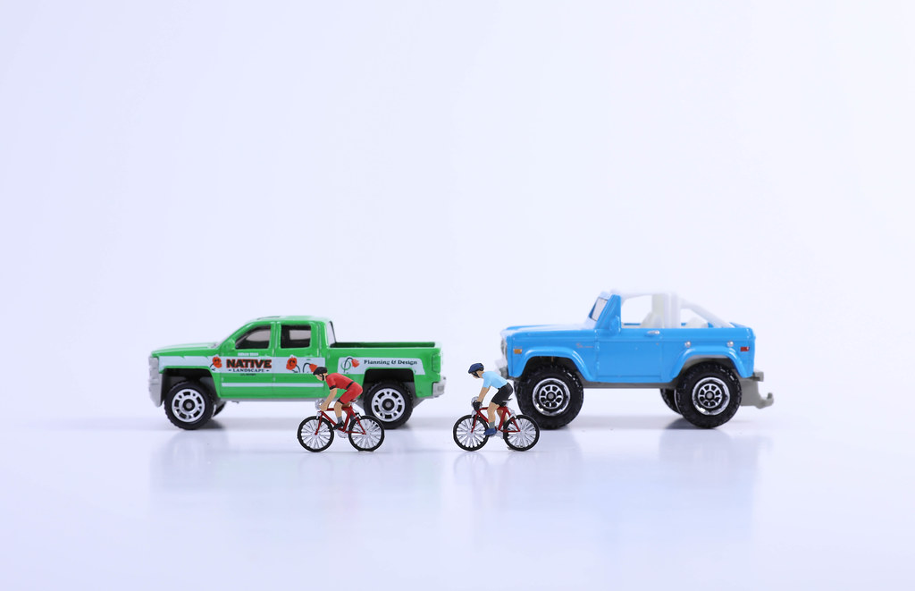 Two cars and cyclists on white background
