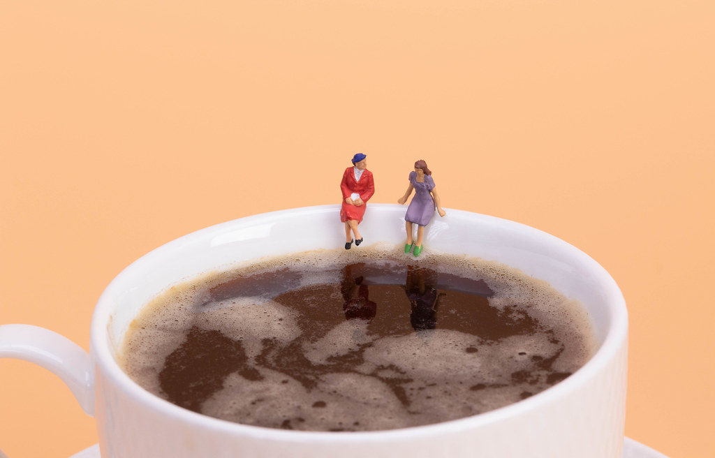 Two girls sitting on hot cup of coffee