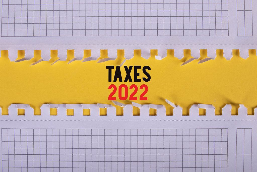 Two pieces of paper with Taxes 2022 text on yellow