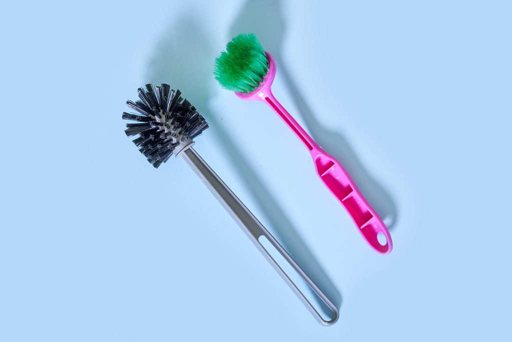 Two toilet brushes on blue background