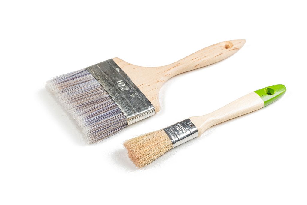 Two wooden paint brushes on a white background