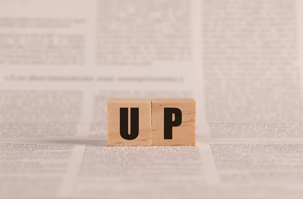 Up written with cubes on a newspaper