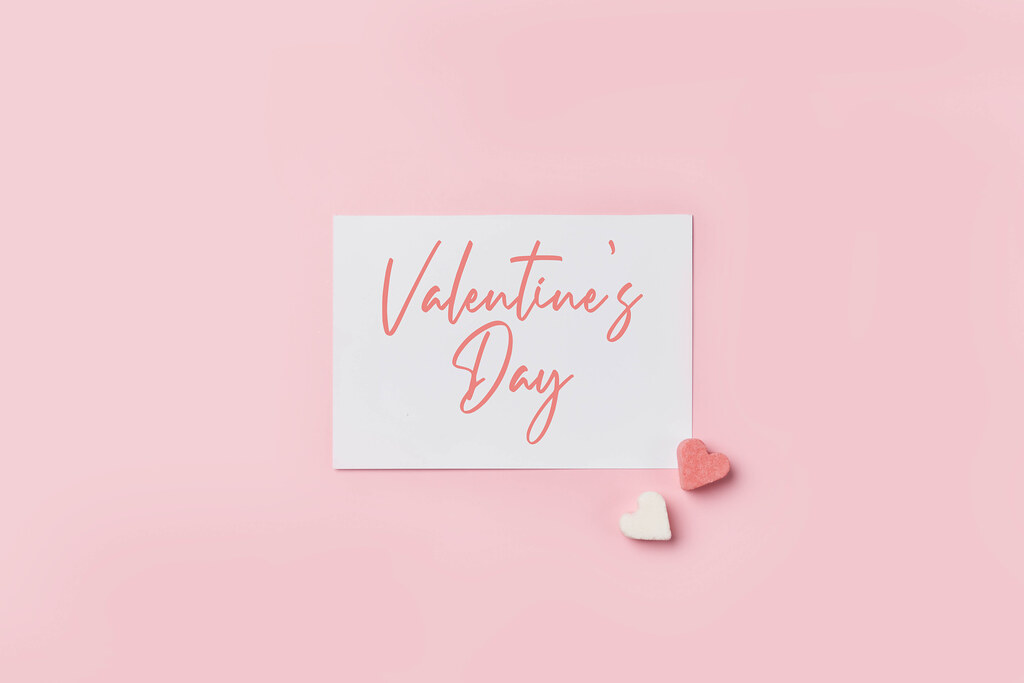 Valentine's day text on paper card with heart shape sugar forms