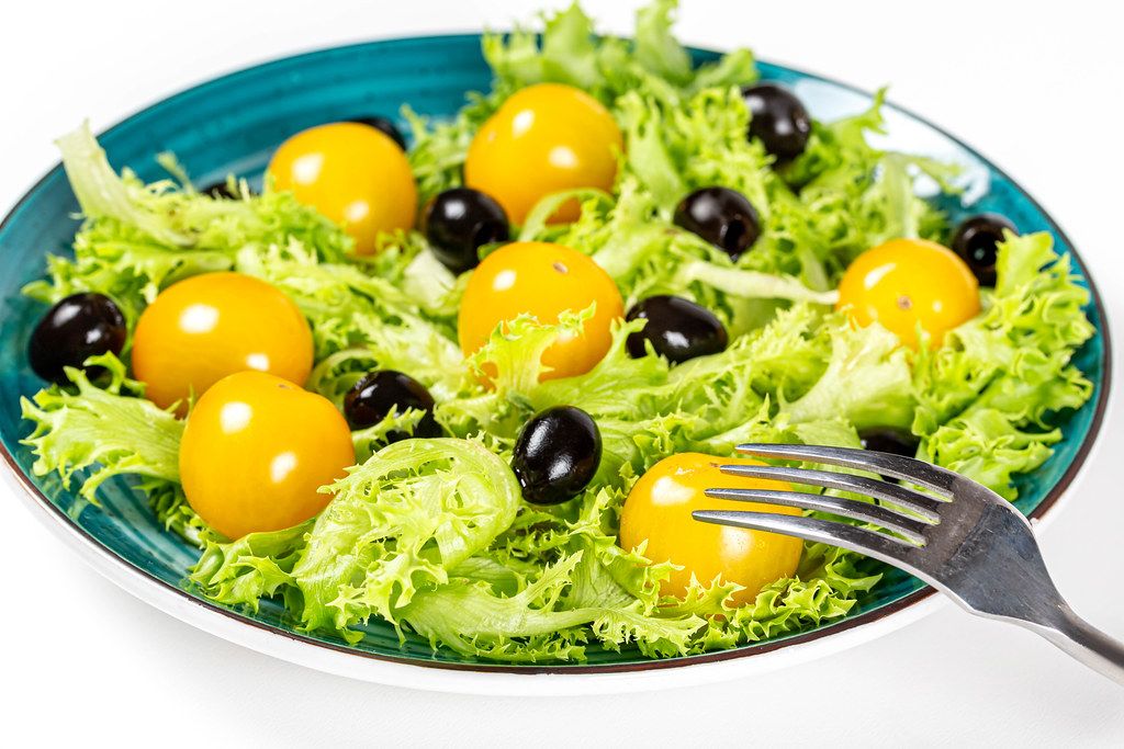Vegetarian fresh salad with lettuce, cherry tomatoes and green olives