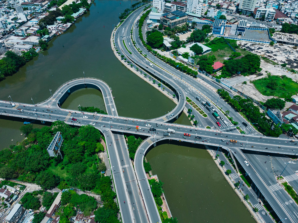 Verkehr mit Motorrollern und Autos auf einer Brücke über Saigon River aus der Luft mit einer Drohne fotografiert in Ho Chi Minh Stadt, Vietnam