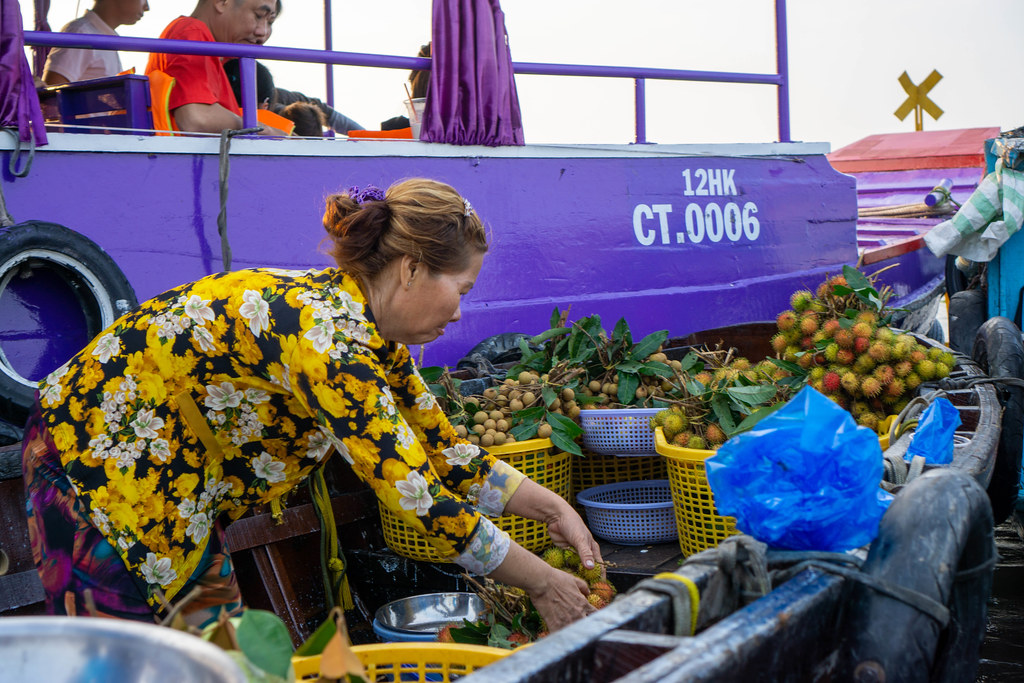 Vietnamesische Frau verkauft frische Longan und Rambutan Früchte auf dem Cai Rang Floating Market in Can Tho, Vietnam