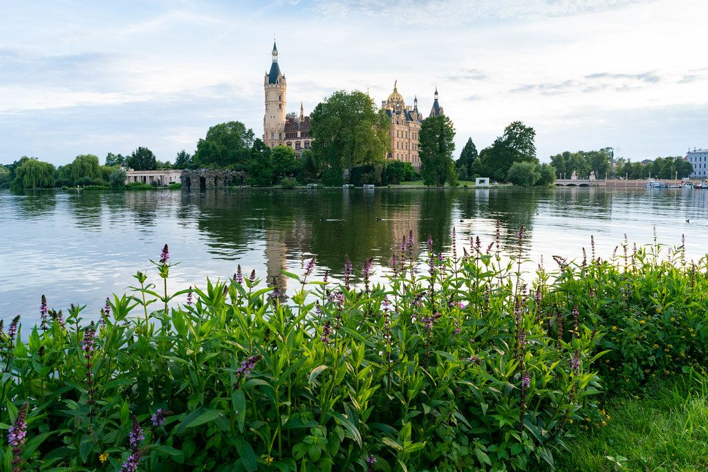 View of a Schwerin castle with its reflection in the lake from nearby park