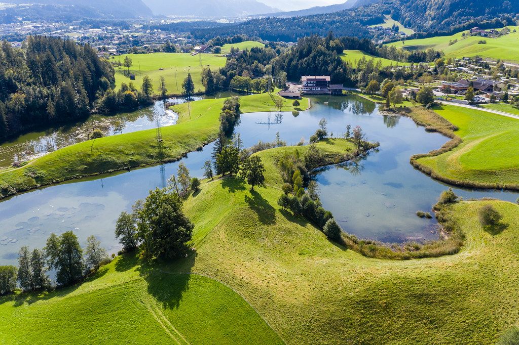 Village of lakes: Krummsee is one of four lakes surrounding Kramsach, Alpbach valley. Drone photo