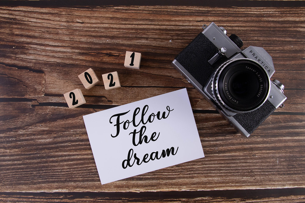 Vintage camera with Follow the dream text on wooden table