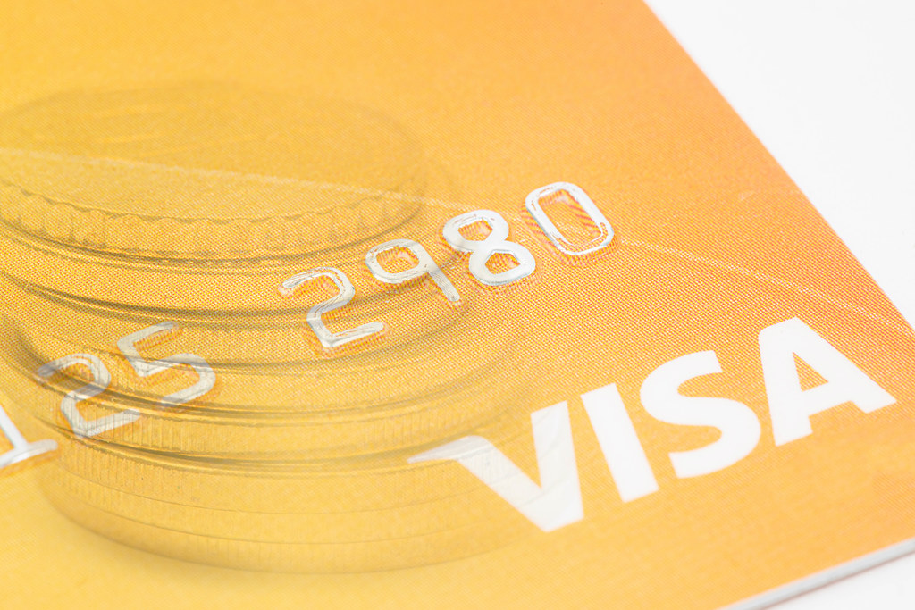 Visa credit card with coins in the background concept with copy space