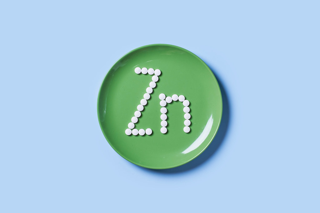 Vitamin Zink symbol on green table