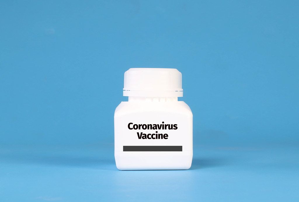 White bottle with Coronavirus Vaccine text on blue background