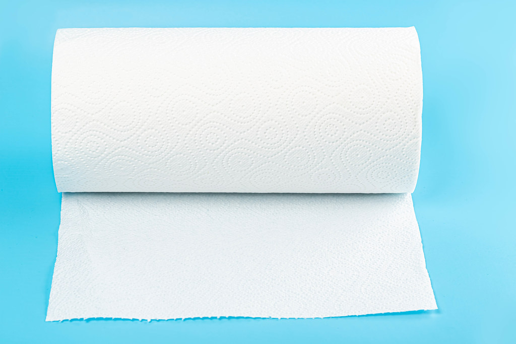 White paper towel roll on blue background