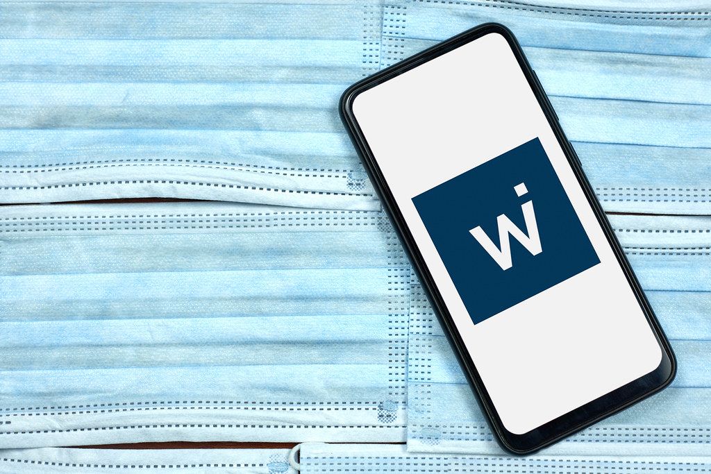 Wirecard logo displayed on smartphone over the face masks