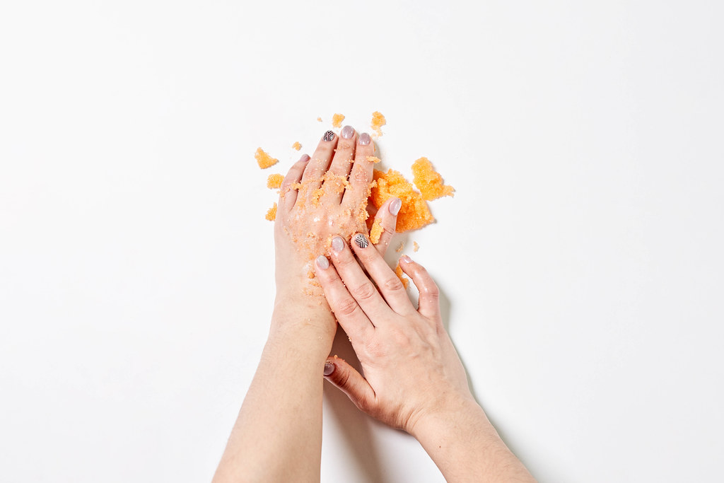 Woman applying on hands citrus fruit natural scrub