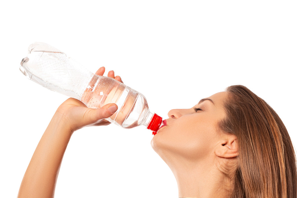 Woman drinking water from a plastic bottle