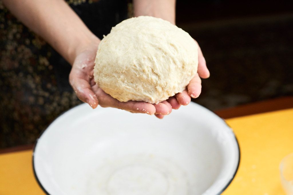 Woman finishing dough prepares in the kitchen