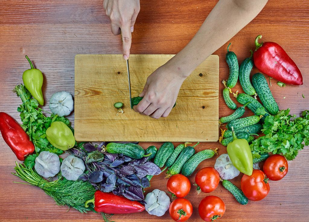 Woman preparing a healthy vegetarian salad with raw vegetables