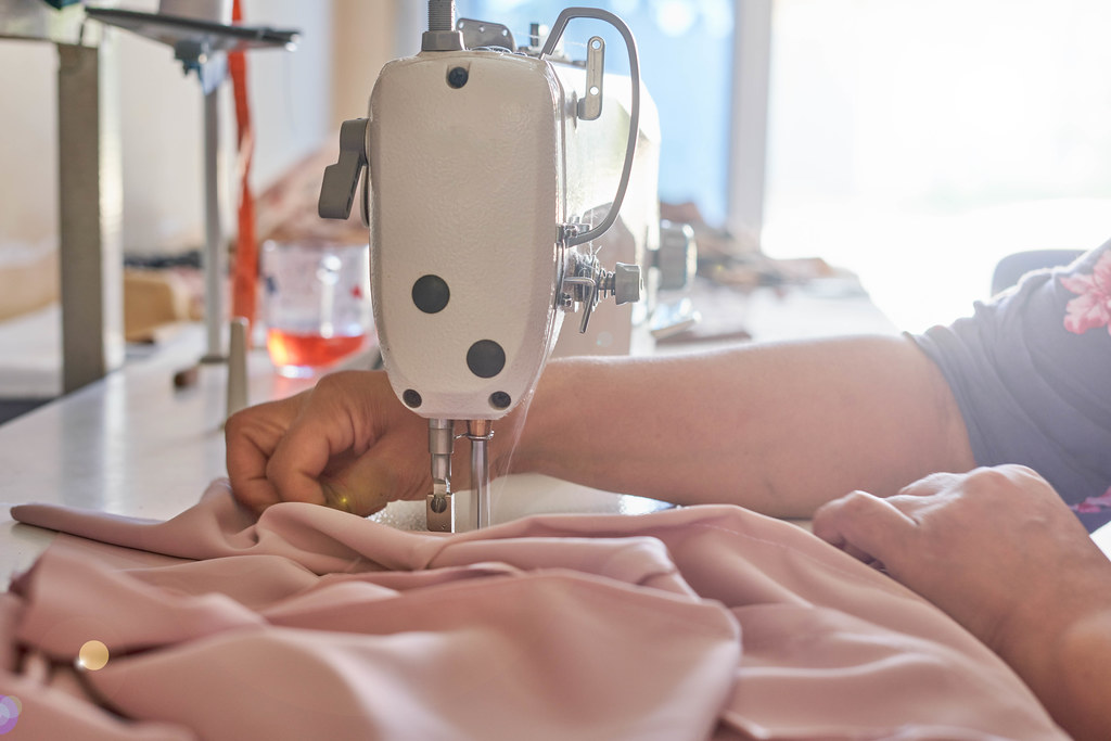 Woman's hands sew on a sewing machine