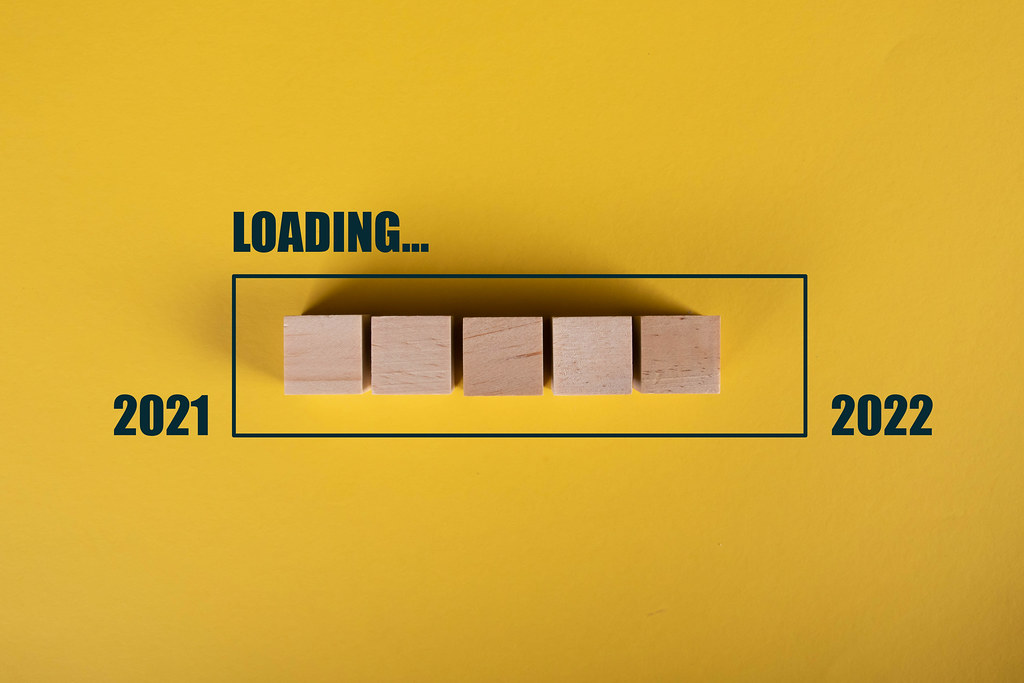 Wooden blocks in loading bar for 2022 on yellow background