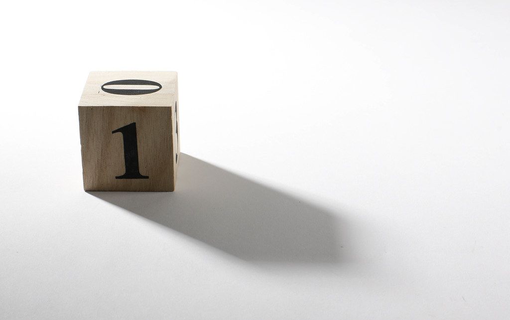 Wooden cube with number 1 on white table