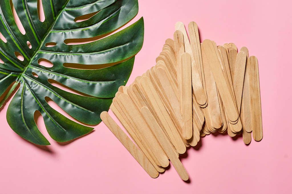 Wooden waxing spatula sticks and big palm leaf