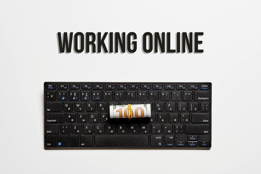 Working online concept with pc keyboard and us dollar bill