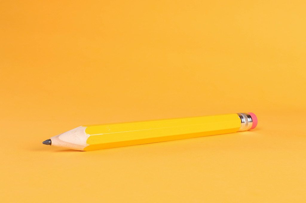 Yellow pencil on orange background