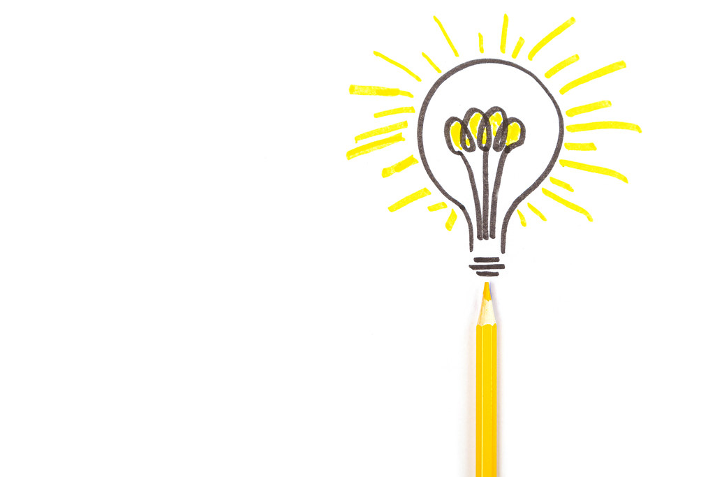 Yellow pencil on white background with drawn light bulb, concept of idea, solution or enlightenment