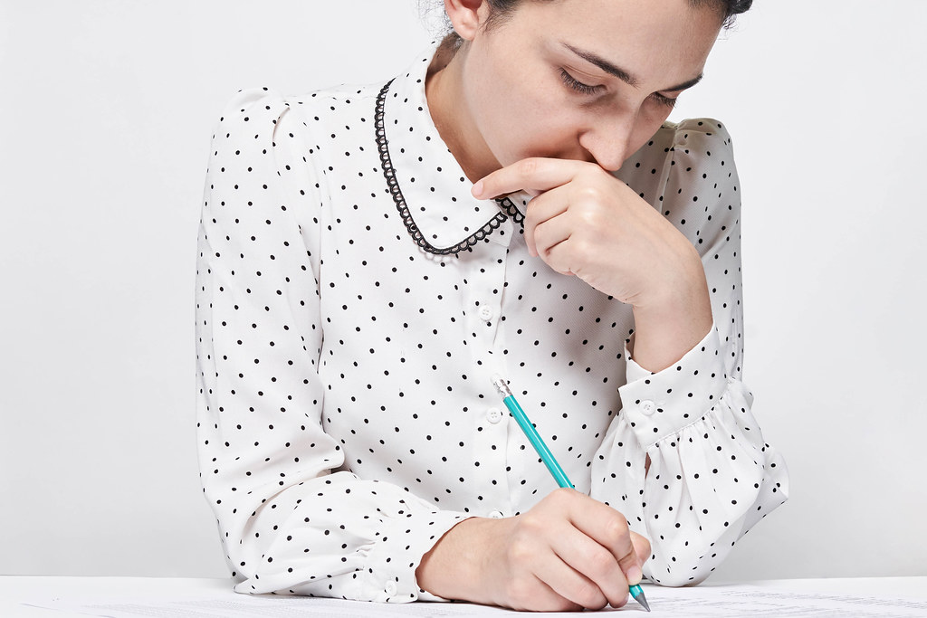 Young thoughtful woman doing test for job employment