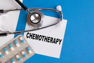 "Chemotherapie", geschrieben auf blauem Ärzteordner, neben Medikamenten und Stethoskop
