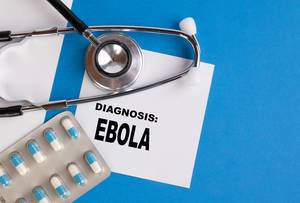 "Diagnose: Ebola", geschrieben auf blauem Ärzteordner, neben Medikamenten und Stethoskop