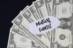 "Mutual funds" Text auf kariertem Zettel mit 100-Dollar-Scheinen