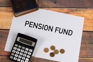 "Pensionsfond"  auf Papier geschrieben, neben einem Taschenrechner, Kleingeld und einer Geldbörse