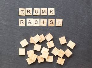 "Trump Racist" wooden tiles on a stone surface