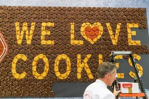 "We love Cookies" - wall lettering made off brown and yellow cookies at anuga food fair in Germany